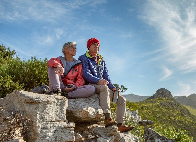 Couple de randonneurs se reposant sur un rocher en montagne