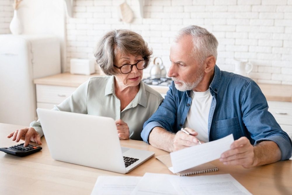 Couple vérifiant ses dépenses devant un ordinateur portable